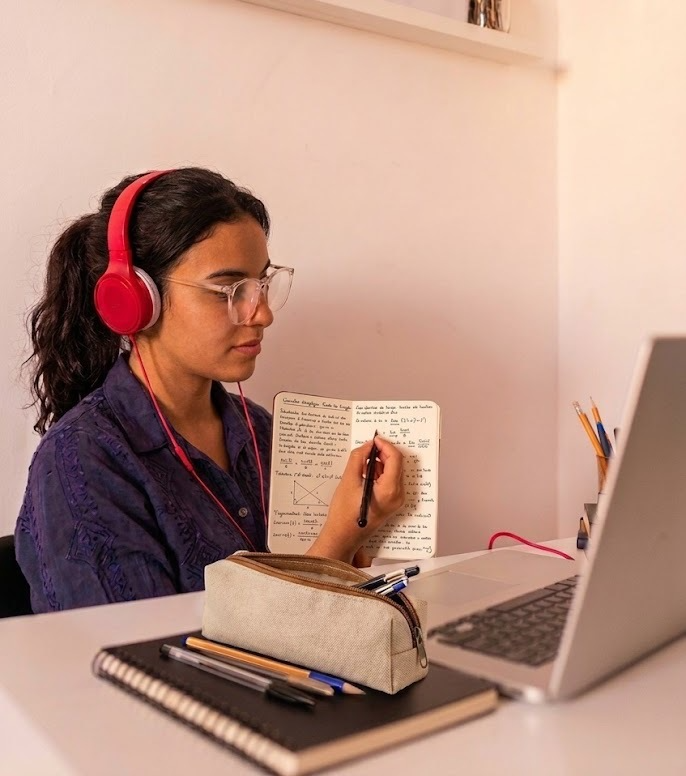Élève travaillant avec son ordinateur et prenant des notes pour son cours Cap Mission